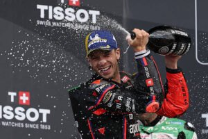 Marco Bezzecchi celebrando con champagne en el podio (Foto de ADRIAN DENNIS/AFP via Getty Images)